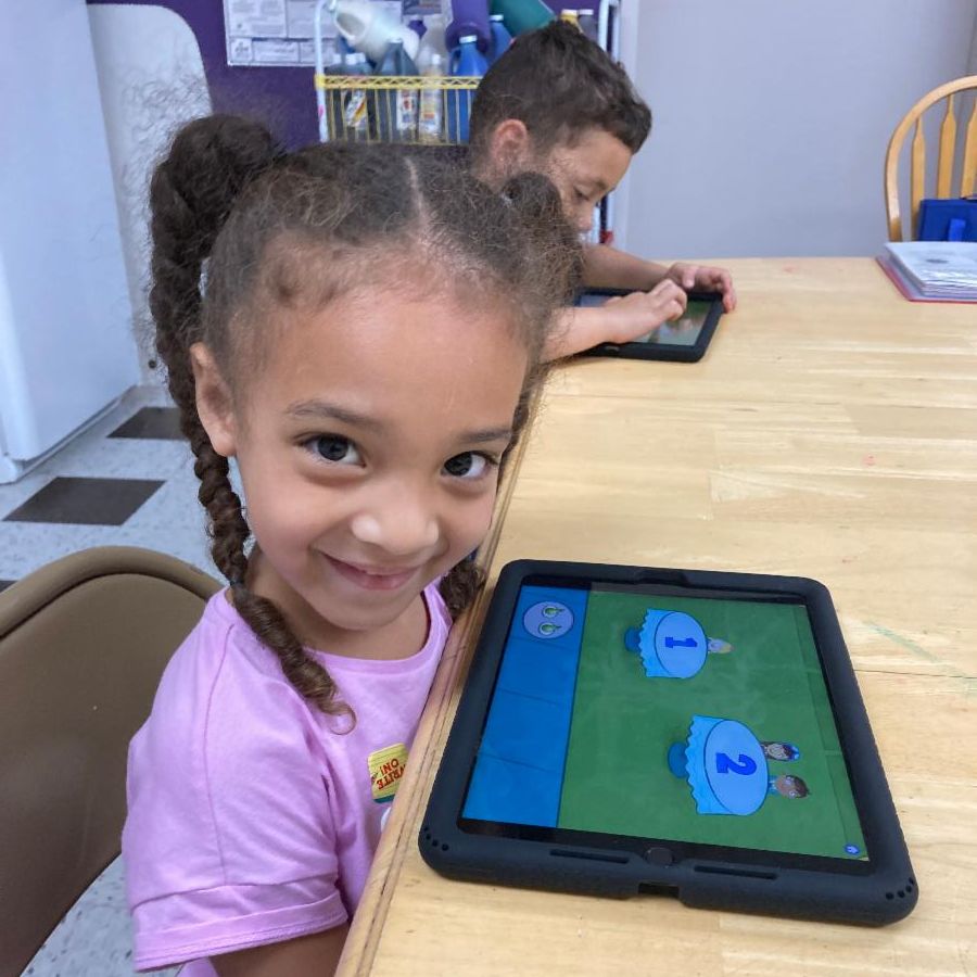 A young girl smiles with her TGH iPad.