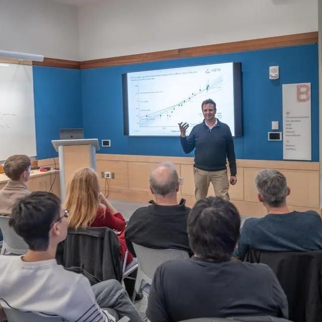 Markus Buehler presenting in front of a crowd of people sitting at desks.