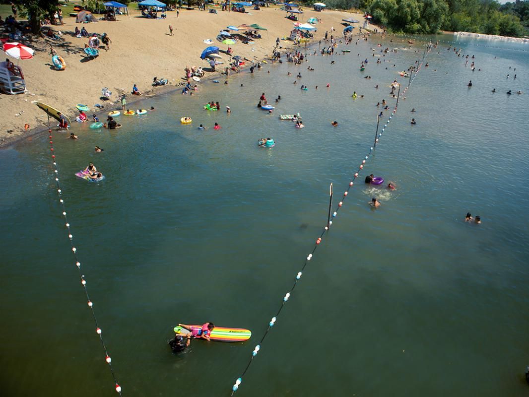 Swimmers playing in water and relaxing on beach