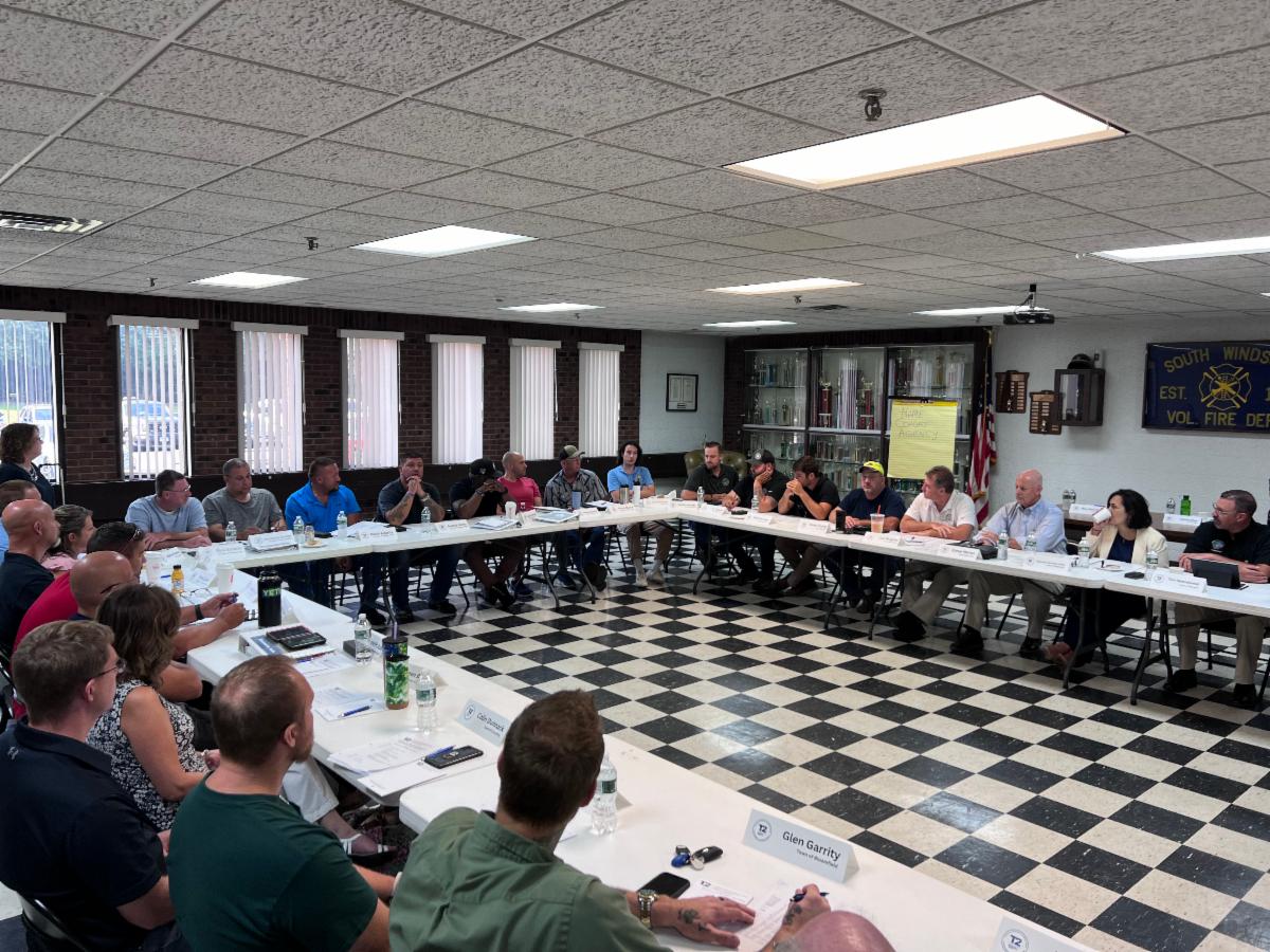 Participants sit around in a circle discussing hot topics in the transportation industry