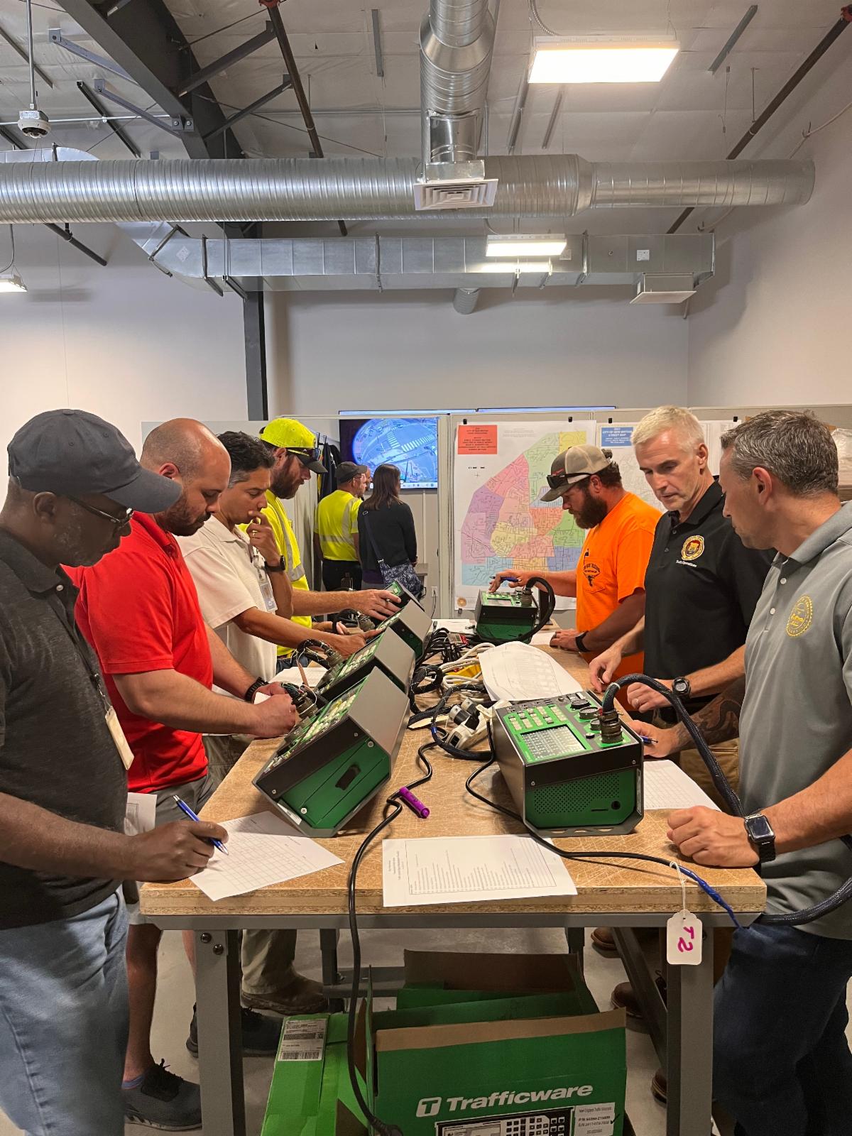 Participants standing around traffic signal controllers working on an exercise