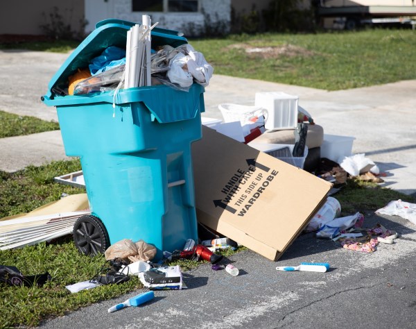 A blue trash can on the ground