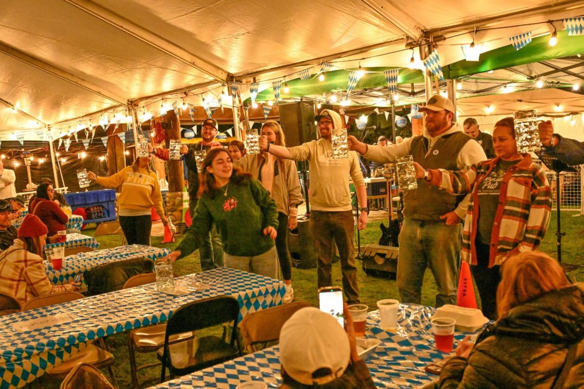 photo of people in under a canopy with picnic tables
