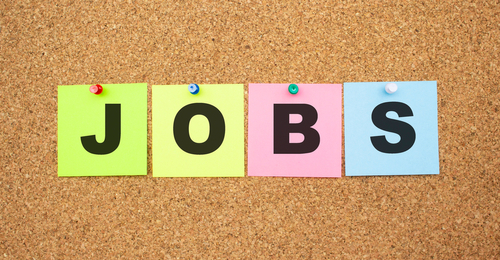 Color notes with letters pinned on a board. Word JOBS. Work space.