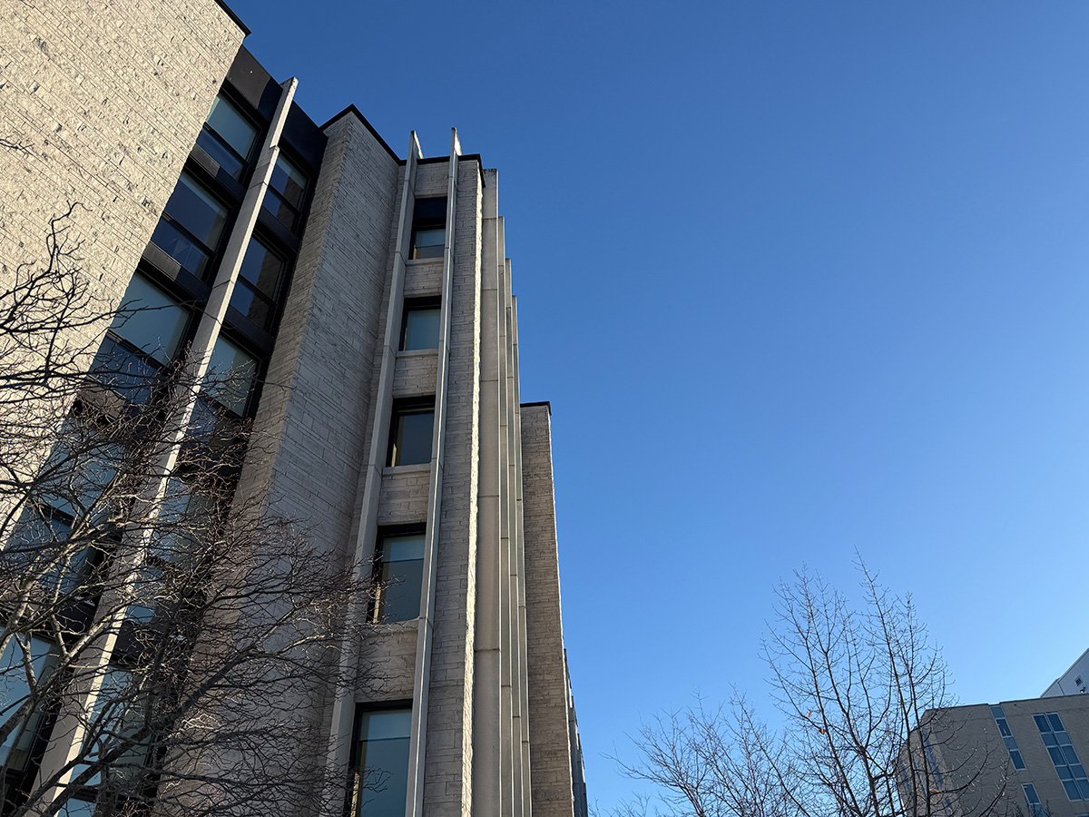 Watts Hall against a blue sky with bare trees