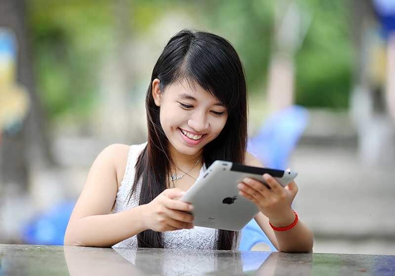 Teen girl smiling and using iPad
