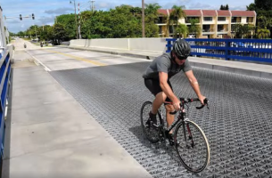 Man riding bike on bridge