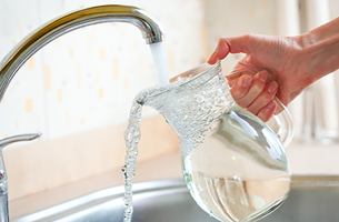 glass pitcher under running water