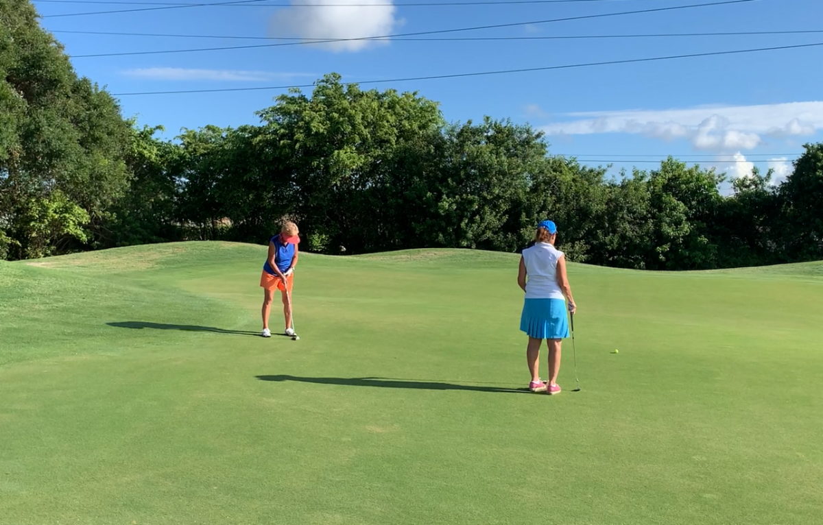 Two women golfing.