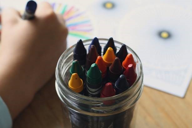 child coloring with crayons