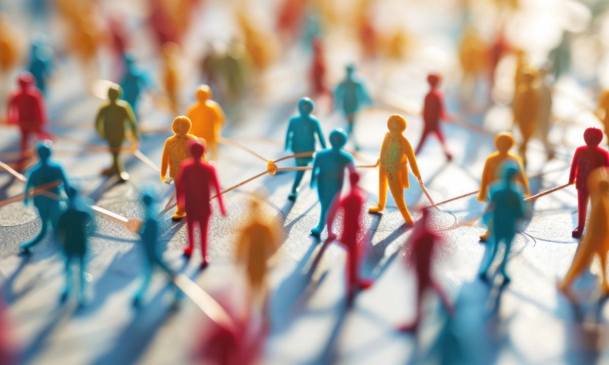 Miniature figures on a network of lines illustrate the interconnectedness of health and community.