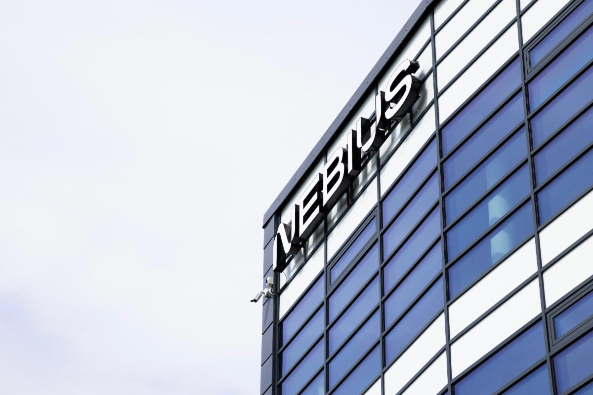 Exterior of a modern glass office building with a large âNebiusâ sign.