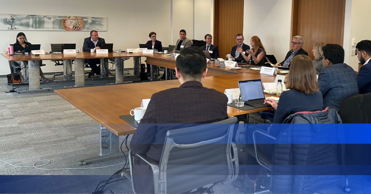 Photo of MPAC AI Roundtable members seated around a conference table, engaged in discussion during a meeting.