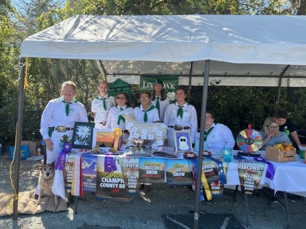 Group picture of Live Oak 4-H Club members and their booth display.