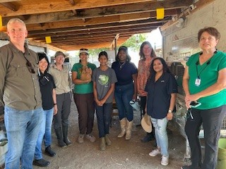 A group of people representing California 4-H and UC ANR standing in a covered outdoor setting, posing for the photo.