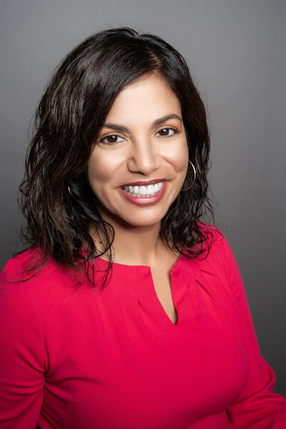 Portrait of woman with dark brown hair and wearing a red shirt