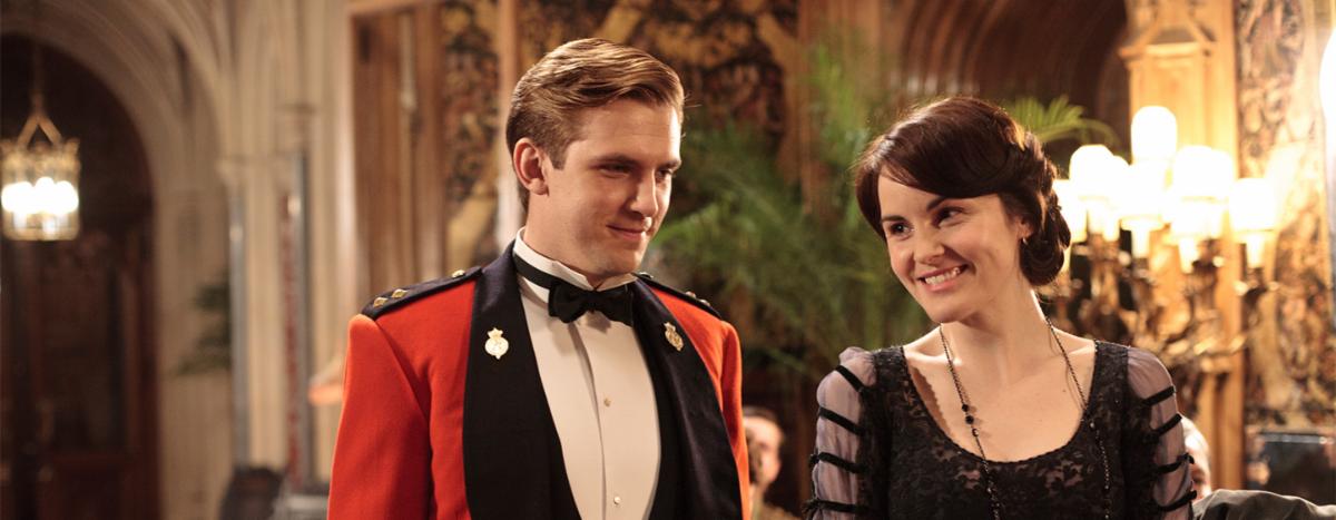A man and woman dressed like royals inside a castle