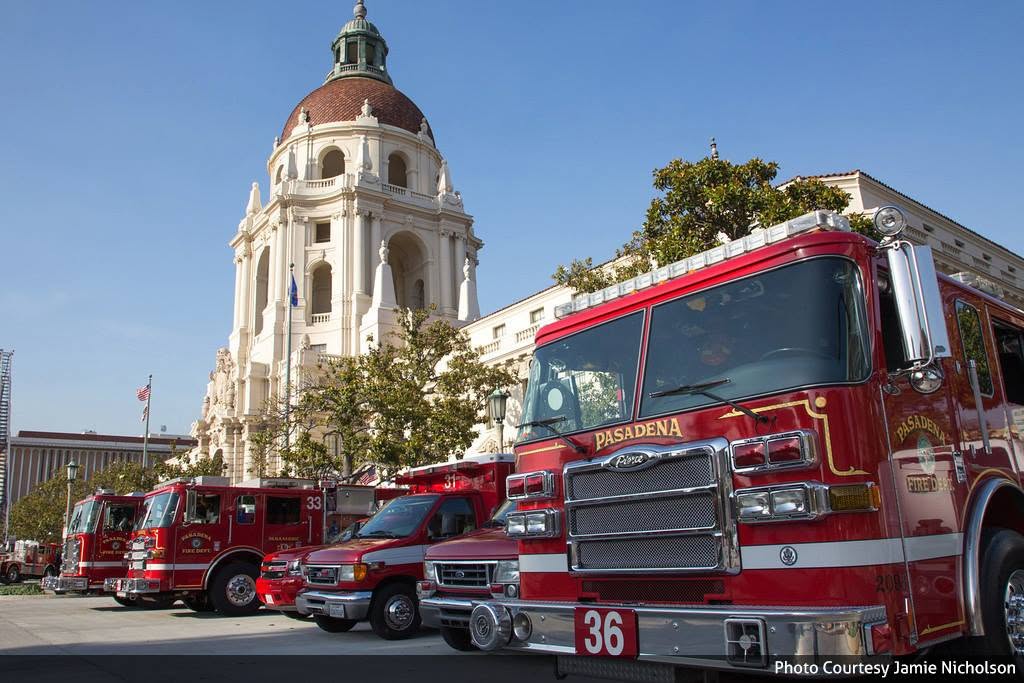 Several red Pasadena Fire Department vehicles are parked outside City Hall