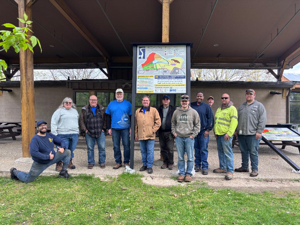 Team of DTE volunteers and EIC staffer Mike Solomon celebrate the assembly of our new Interpretive Trails wayfinding sign!