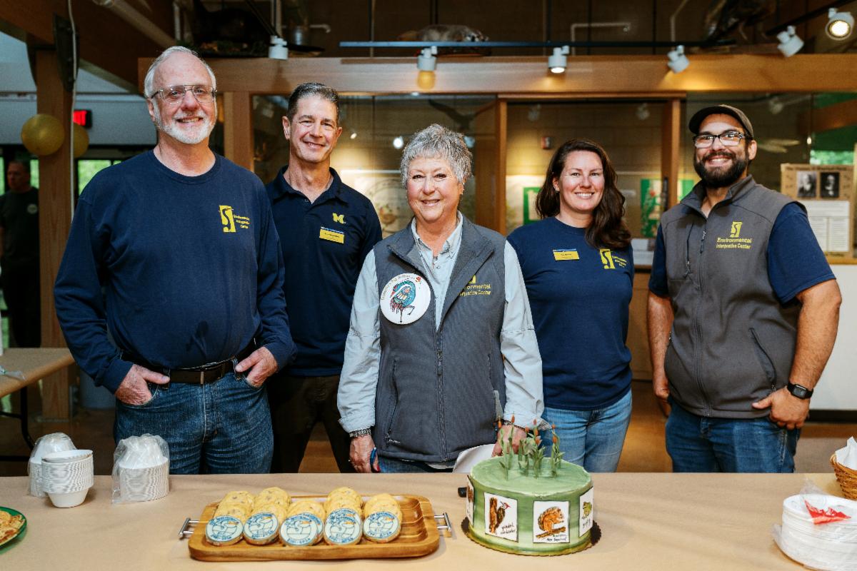 The EIC staff in front of the 25th birthday cake, awaiting the guests that will be crowding the table for a slice! 
