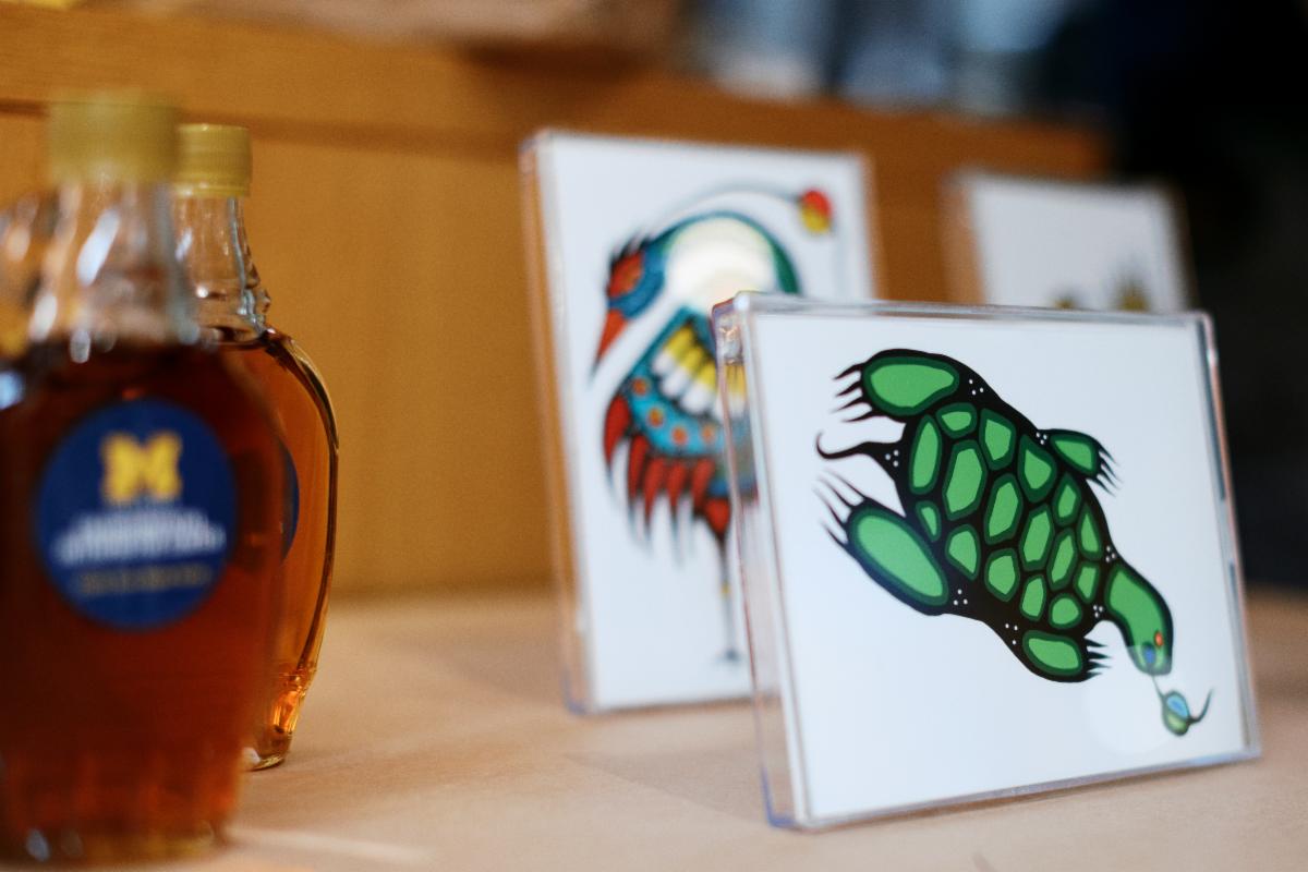 Bottles of EIC-made maple syrup and examples of Hadassah GreenSky's prints, available as fundraiser merchandise.ts