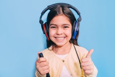 Cute little mixed race child while procedure hearing exam. Girl wearing special headphones getting hearing test, audiometry