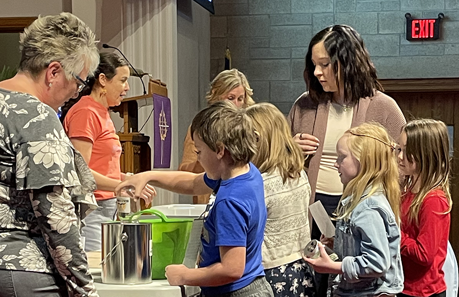 Children present their Built on the Rock gifts in chapel