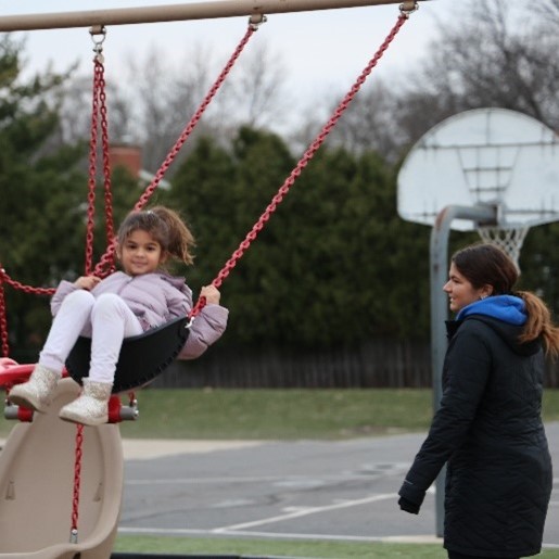Child on Swingset and Staff Member