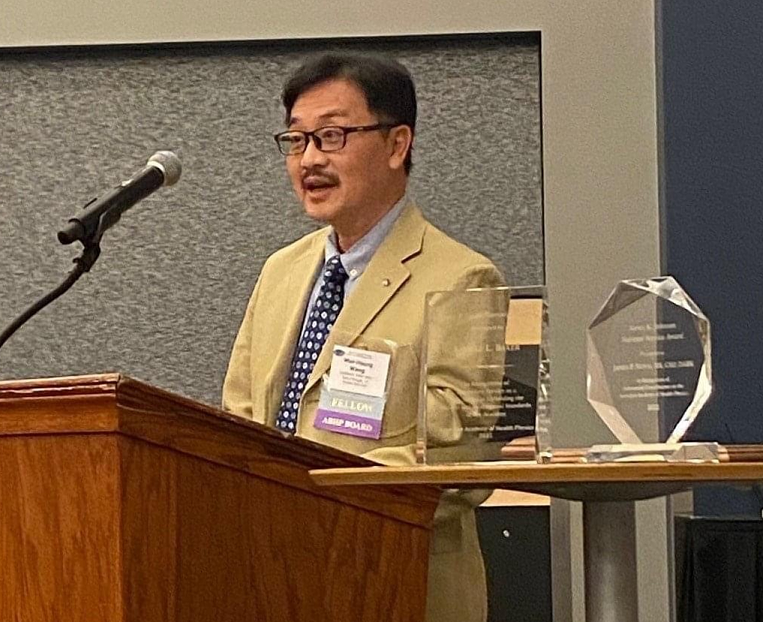 Wang with award at podium