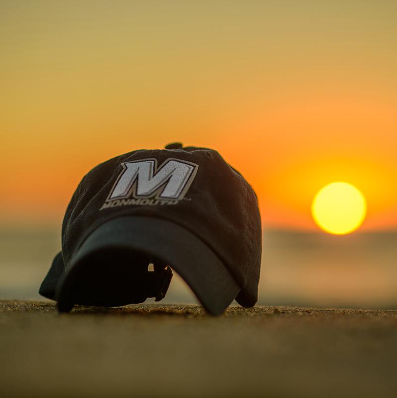 A Monmouth University cap on a beach