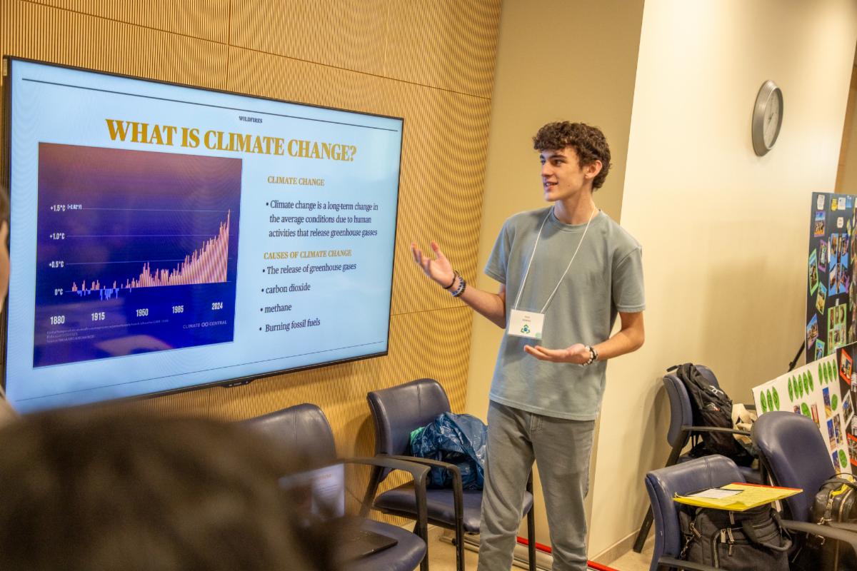 A student standing before a slideshow presentation