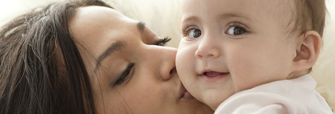 Mom kissing a baby