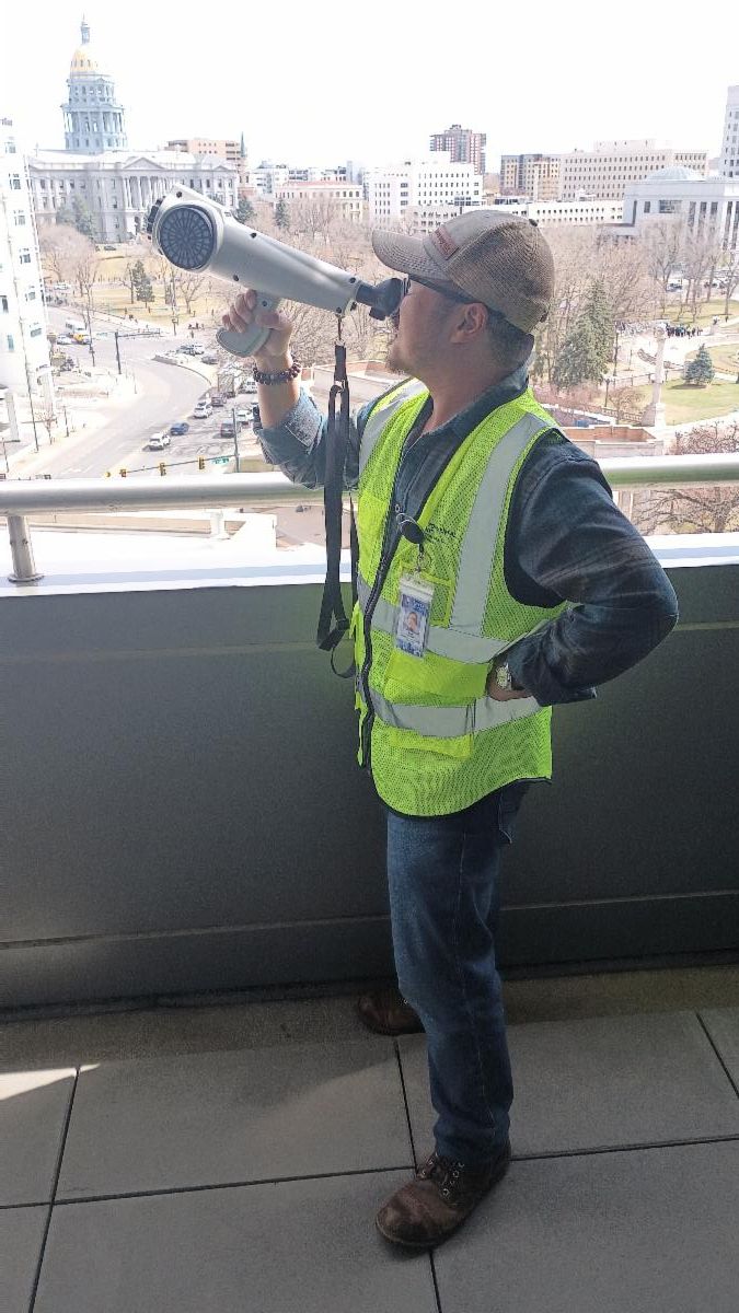 Person with yellow vest using nasal ranger outside