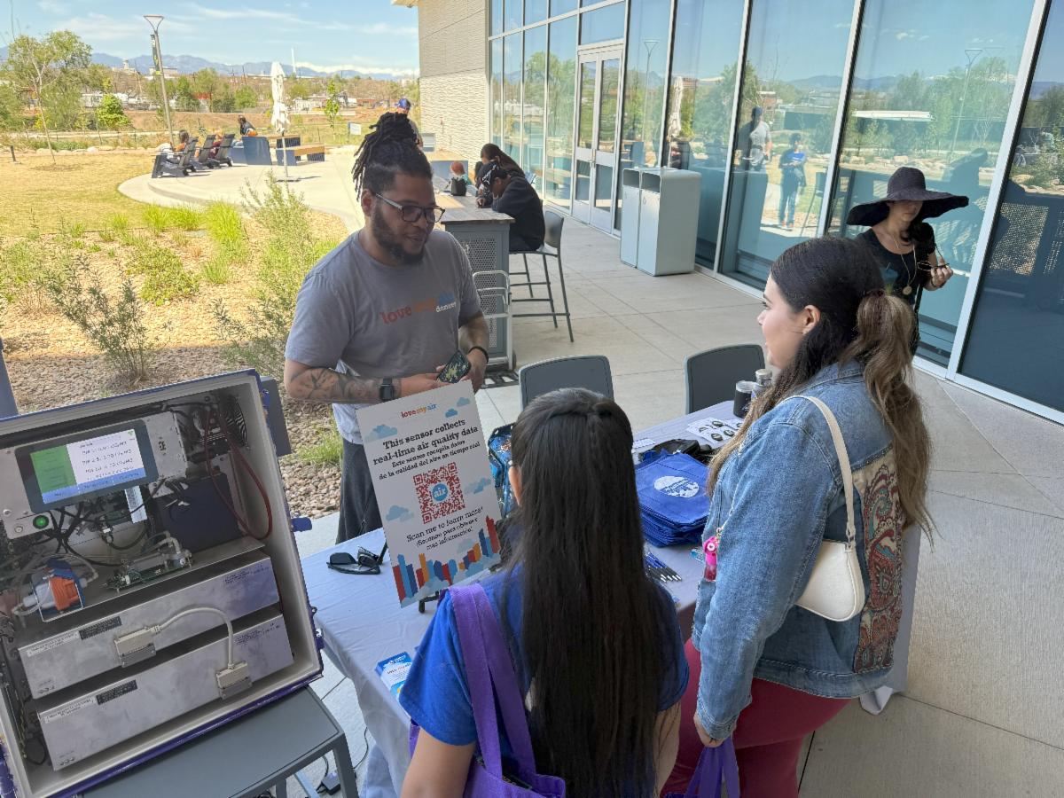 People talking at event booth outdoors