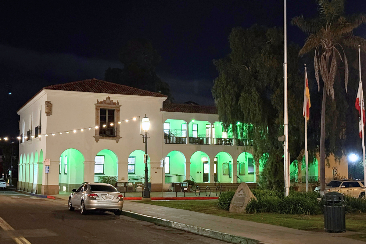 City Hall illuminated by green lights.