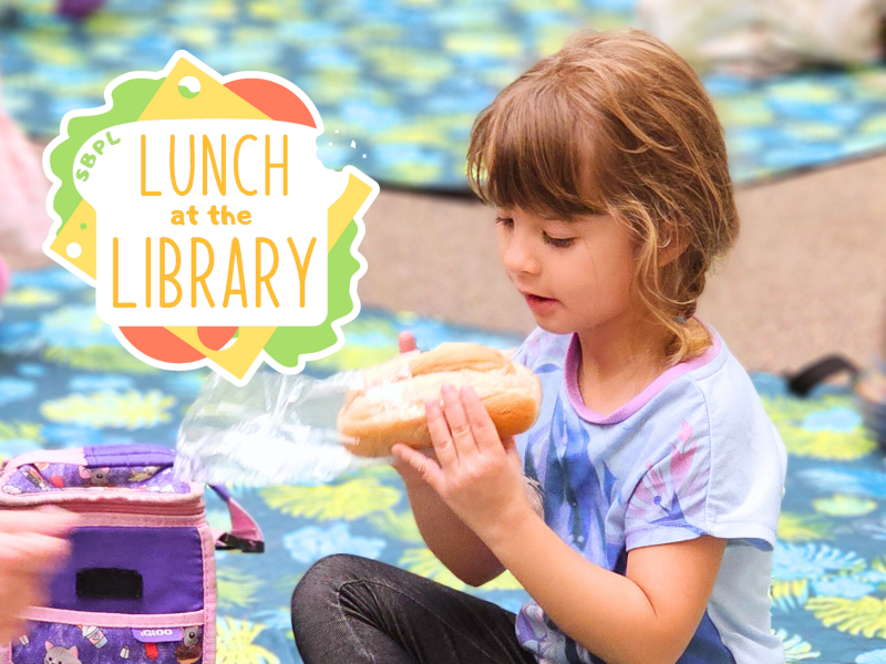 Child eating a sandwich, text reading Lunch at the Library.