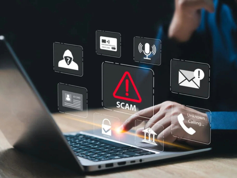 scam alert over image of person using a laptop.