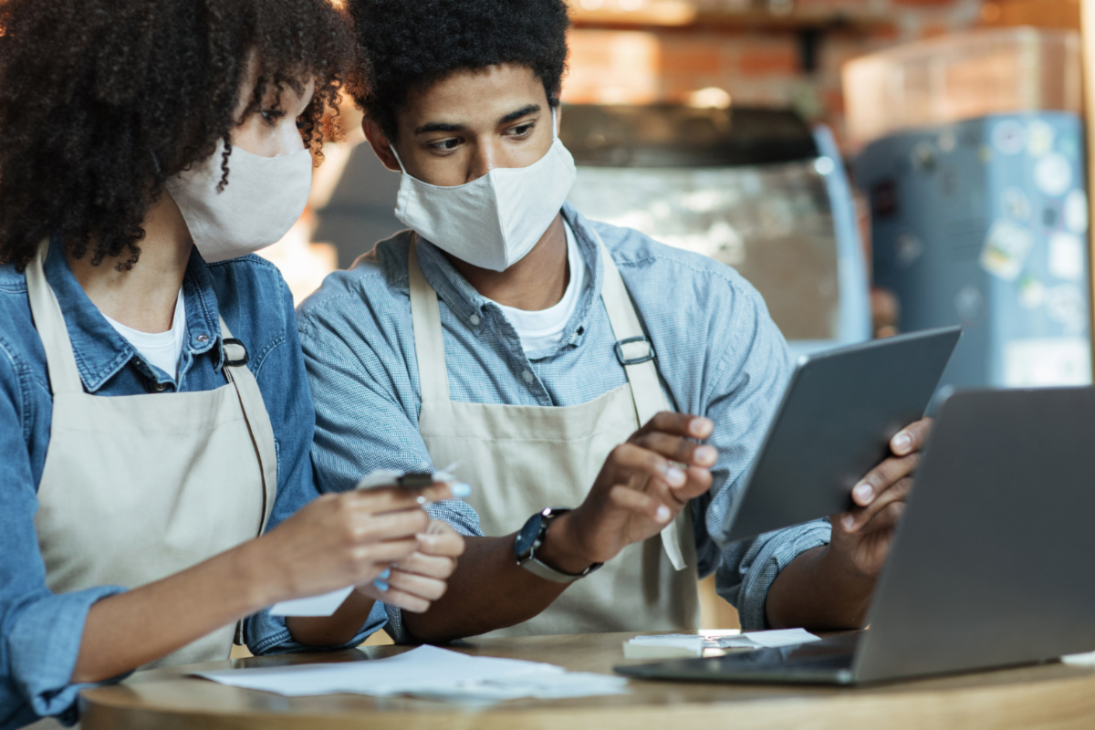 People in Masks Looking at Tablet