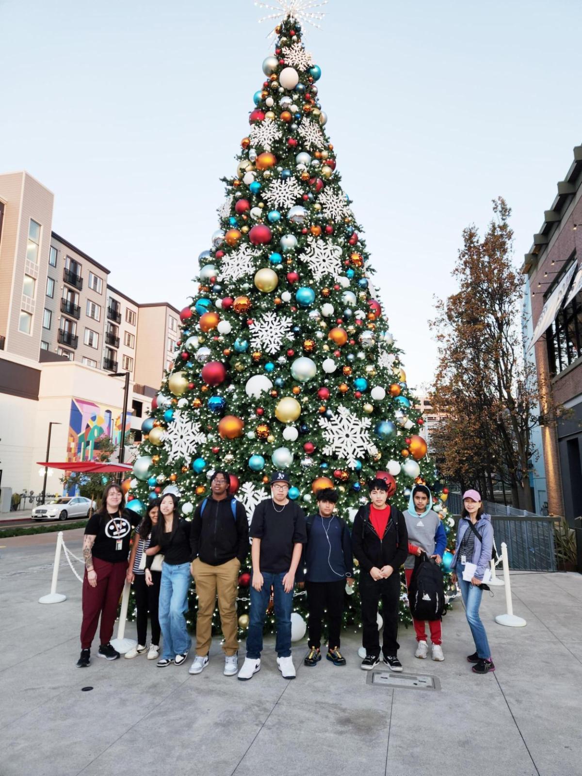 Group of youth standing in front of the Christmas Tree at BayStreet in Emeryville.