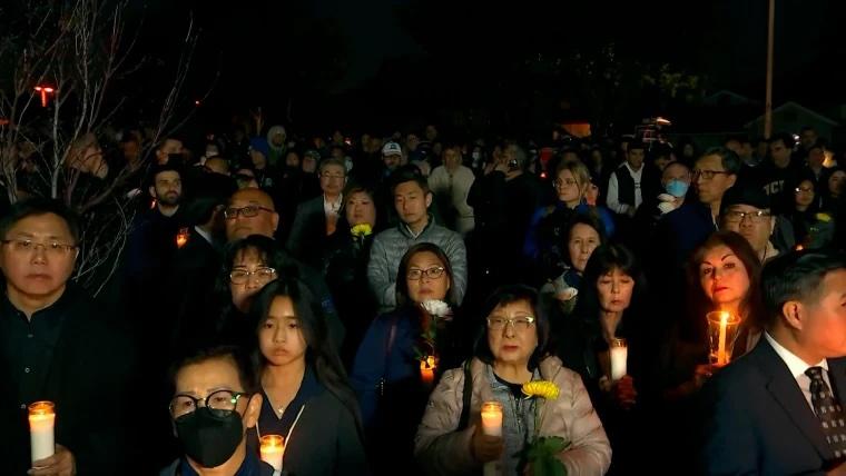 A group of individuals hold candles at night