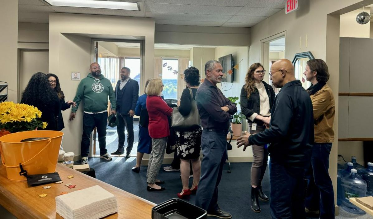 Adam Gomez and Samantha Hamilton chatting among crowd at open house