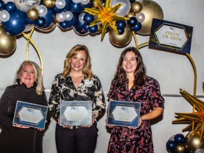 Three women are holding up certificates