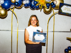 A woman is holding an award