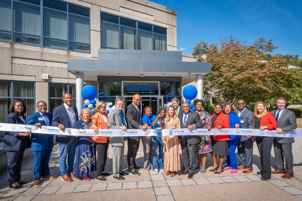 Group of people standing in front of a large ribbon