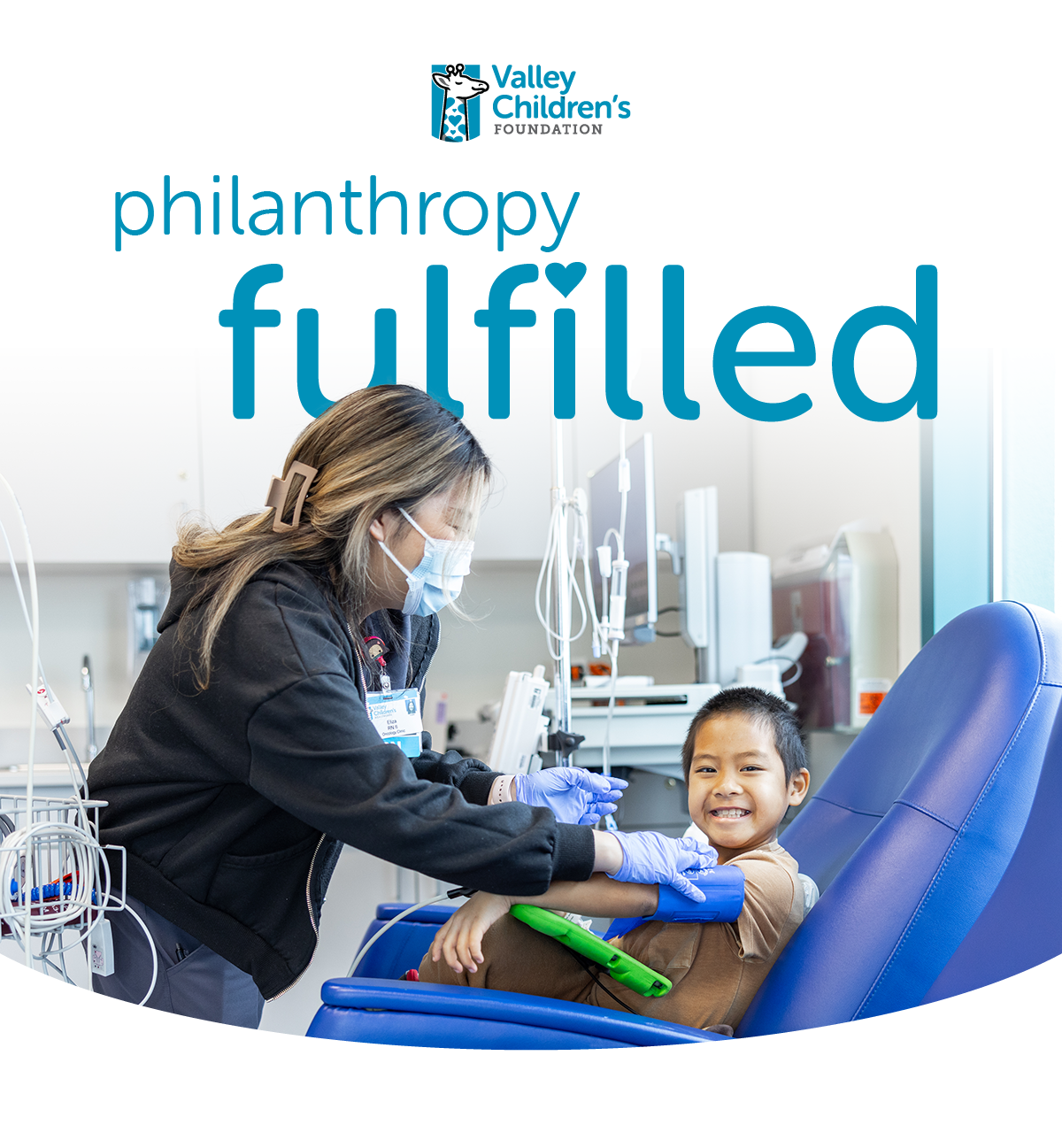 A nurse with a mask helps a smiling boy in an infusion chair