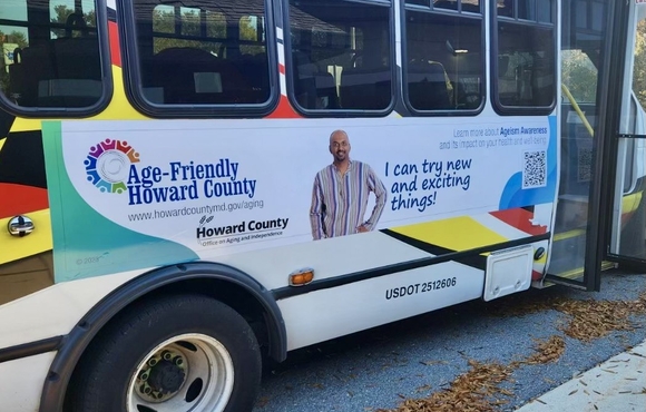 Ad on the side of a bus that says Age friendly Howard County and a QR code to scan