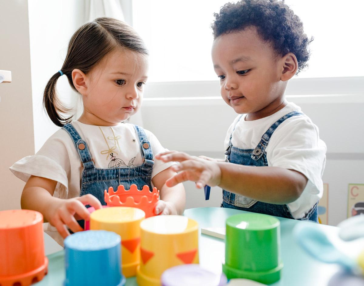 A photo of two children playing with blocks.