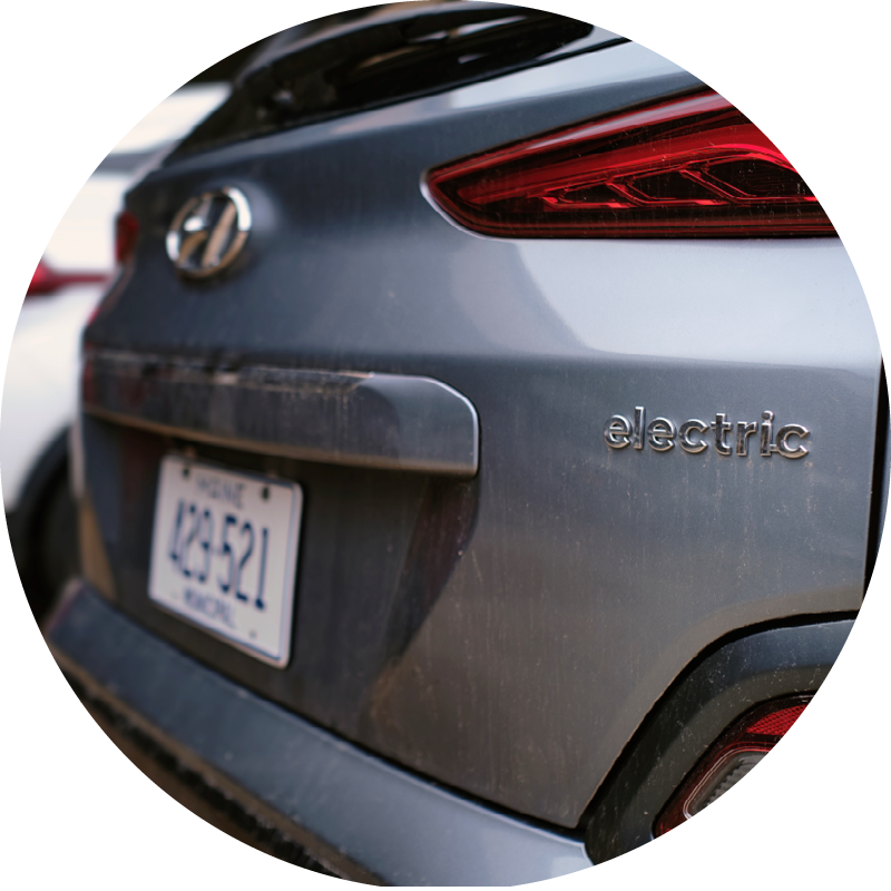 A car at the Electric Vehicle Expo with the word "electric" on its back bumper