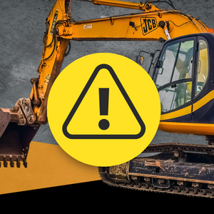 Photo of excavator with a caution sign in the middle