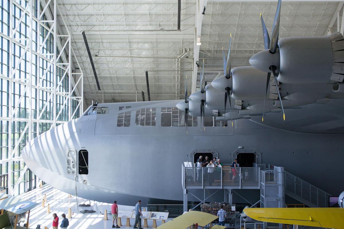 Nose and leading edge of wing of the flying boat with people seen on the entry platform along the fuselage